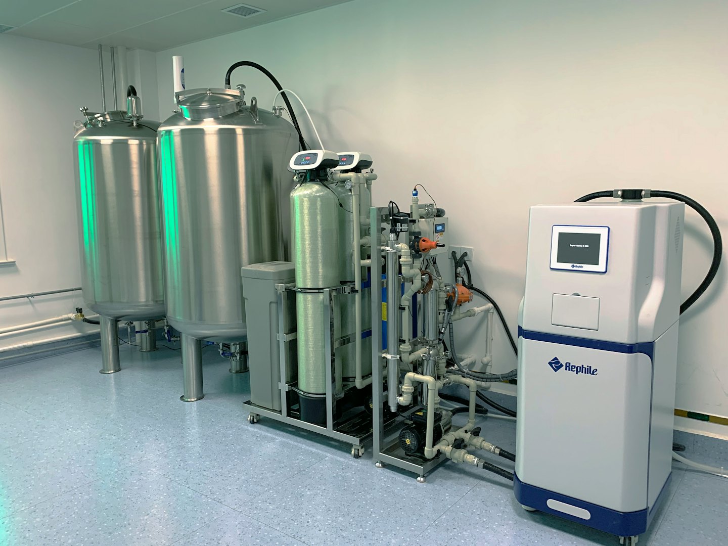 Industrial water purification system with stainless steel tanks and filtration units.