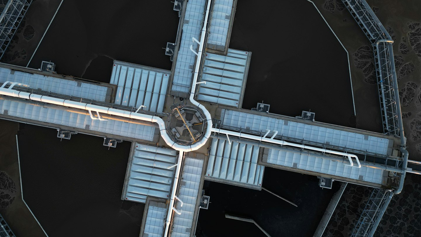 Circular water treatment facility with pipes connecting to four tanks.